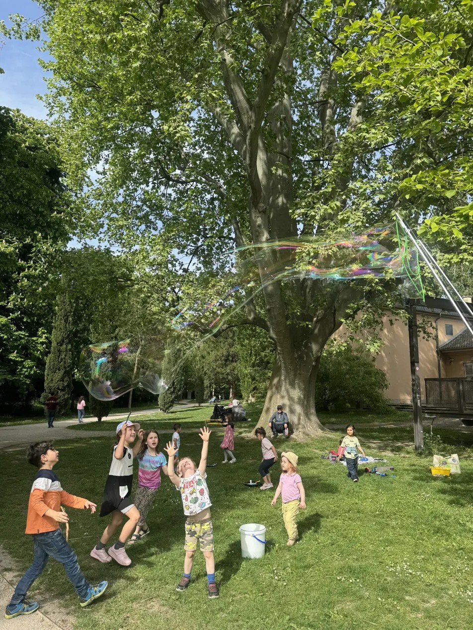 Kinder spielen mit Riesenseifenblasen